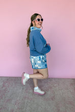 Load image into Gallery viewer, Woman in blue sweatshirt and patterned shorts posing against a pink wall