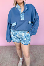 Load image into Gallery viewer, Person wearing a blue floral outfit against a pink background