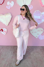 Load image into Gallery viewer, Woman in pink set with sunglasses standing in front of a pink wall with heart shapes