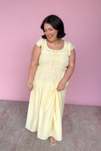 Load image into Gallery viewer, Woman wearing a yellow midi dress against a pink background