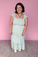 Load image into Gallery viewer, Woman wearing a green and white floral striped midi dress against a pink background