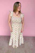 Load image into Gallery viewer, Woman wearing a pink and green floral midi dress against a pink background