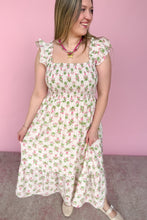 Load image into Gallery viewer, Woman wearing a pink and green floral midi dress against a pink background