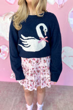 Load image into Gallery viewer, Person wearing a navy sweater with a swan design against a pink background