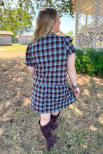 Load image into Gallery viewer, Girl wearing a brown and blue plaid skort and front tie top set with brown boots standing in front of a gazebo.