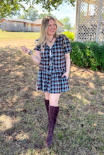 Load image into Gallery viewer, Girl wearing a brown and blue plaid skort and front tie top set with brown boots standing in front of a gazebo.
