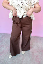 Load image into Gallery viewer, Girl wearing brown wide leg pants with cream and brown polkadot top in front of a pink backdrop.