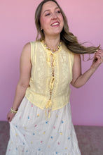 Load image into Gallery viewer, Woman wearing a yellow lace top and white skirt with colorful embroidered flowers against a pink background
