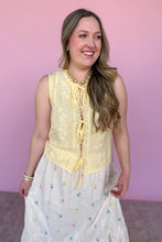 Load image into Gallery viewer, Woman wearing a yellow top and white skirt with colorful embroidered flowers against a pink background