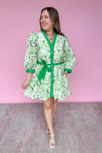Load image into Gallery viewer, Woman wearing a green and white patterned dress with a belt against a pink background