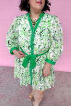Load image into Gallery viewer, Woman wearing a green and white patterned dress with a belt against a pink background