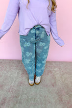 Load image into Gallery viewer, Person wearing a light purple sweater and floral jeans against a pink wall.