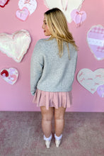 Load image into Gallery viewer, Woman wearing a gray sweater and pink skirt against a pink wall with heart decorations back view