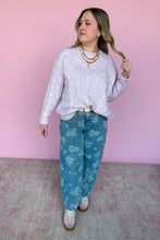 Load image into Gallery viewer, Woman wearing a light purple sweater and blue floral pants against a pink background