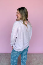Load image into Gallery viewer, Woman wearing a light purple sweater and blue floral pants against a pink background back view