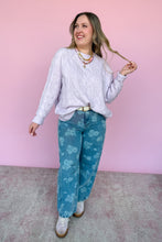 Load image into Gallery viewer, Woman wearing a light purple sweater and blue floral jeans against a pink background
