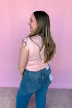 Load image into Gallery viewer, Girl wearing a pink cap sleeve top and denim jeans, standing in front of a pink backdrop.