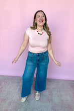 Load image into Gallery viewer, Girl wearing a pink cap sleeve top and denim jeans, standing in front of a pink backdrop.