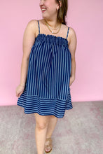 Load image into Gallery viewer, Girl in blue stripe spaghetti strap mini dress with pockets standing in front of a pink wall.