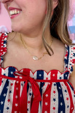 Load image into Gallery viewer, Person wearing a red, white, and blue dress with star pattern and gold and pearl necklace.