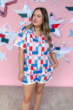 Load image into Gallery viewer, Woman wearing a colorful patchwork dress against a pink wall with star decorations.