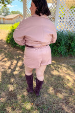Load image into Gallery viewer, Girl wearing a faux pink leather jacket and skort set with brown undershirt and brown knee high boots standing in front of a gazebo.
