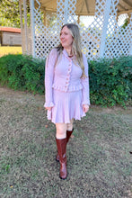 Load image into Gallery viewer, Girl wearing a pink ruffle cardigan skirt set with brown knee high boots standing in front of a gazebo.