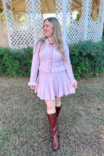 Load image into Gallery viewer, Girl wearing a pink ruffle cardigan skirt set with brown knee high boots standing in front of a gazebo.
