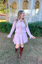 Load image into Gallery viewer, Girl wearing a pink ruffle cardigan skirt set with brown knee high boots standing in front of a gazebo.