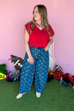 Load image into Gallery viewer, Woman wearing polkadot denim barrel jeans with a red top standing in front of a pink backdrop.