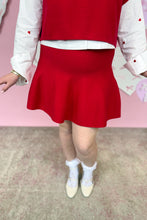 Load image into Gallery viewer, Person wearing a red skirt and white top with a pink background