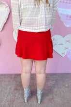 Load image into Gallery viewer, Person wearing a white lace top and red skirt with a pink heart-patterned background
