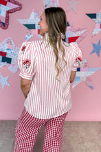 Load image into Gallery viewer, Woman wearing a red and white striped shirt and red checkered pants in front of a colorful star-patterned wall.