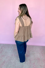 Load image into Gallery viewer, Girl wearing a brown gingham babydoll tank with dark denim jeans in front of a pink backdrop. 
