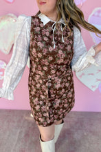 Load image into Gallery viewer, Woman wearing a floral dress with a white blouse underneath against a pink background
