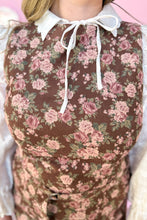 Load image into Gallery viewer, Floral patterned brown dress over a white shirt with a pink background
