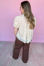 Load image into Gallery viewer, Girl wearing brown wide leg pants with cream and brown polkadot top in front of a pink backdrop.
