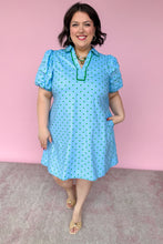 Load image into Gallery viewer, Woman wearing a blue dress with green polka dots against a pink background
