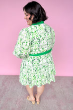 Load image into Gallery viewer, Woman wearing a green and white patterned dress against a pink background
