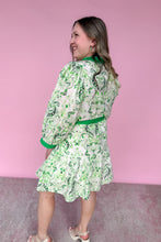 Load image into Gallery viewer, Woman wearing a green and white patterned dress against a pink background
