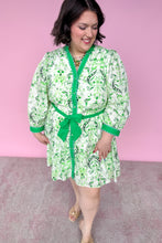 Load image into Gallery viewer, Woman wearing a green and white patterned robe against a pink background
