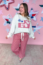 Load image into Gallery viewer, Woman wearing a white sweatshirt with a red and blue graphic and red checkered pants against a pink wall with star decorations.
