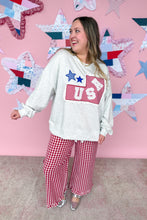 Load image into Gallery viewer, Woman wearing a white sweatshirt with a red and blue graphic and red checkered pants in front of a pink wall with star decorations.
