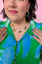 Load image into Gallery viewer, Person wearing a green and blue floral dress with Chunky Gold and Clear jewelry against a pink background
