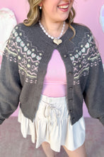 Load image into Gallery viewer, Person wearing a gray patterned cardigan over a pink top and white skirt on a pink background
