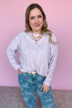 Load image into Gallery viewer, Woman wearing a light purple sweater and blue floral pants against a pink background
