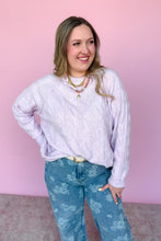 Load image into Gallery viewer, Woman wearing a light purple sweater and blue floral pants against a pink background
