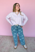 Load image into Gallery viewer, Woman wearing a lavender sweater and blue floral jeans against a pink background
