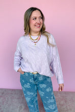 Load image into Gallery viewer, Woman wearing a light purple sweater and blue floral pants against a pink background
