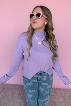 Load image into Gallery viewer, Woman wearing a purple sweater and blue jeans with pink sunglasses against a pink background
